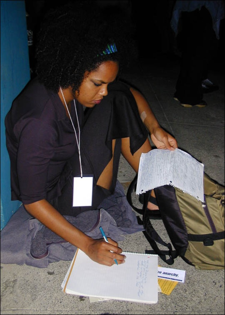 Figure 11-1: Walidah Imarisha writes in her journal.